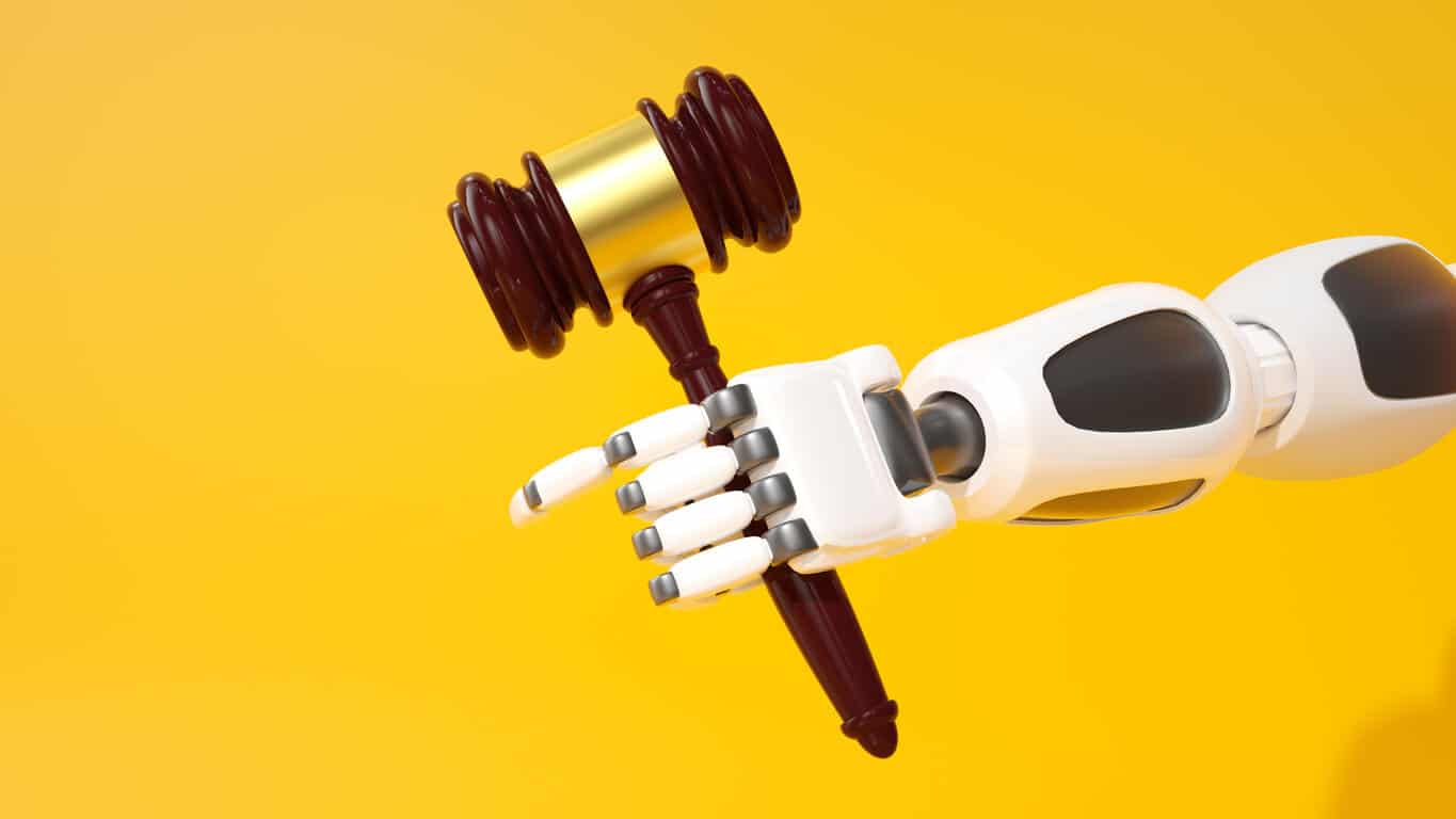 Main robotisée tenant un marteau de juge, concept de conformité IA ou de justice basée sur l'IA, fond jaune, rendu 3D, contraste élevé, composition minimaliste, technologie futuriste, intelligence artificielle, droit européen. Source : iStock.