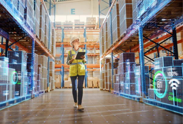 Image d'illustration de l'article LabSense sur l'infrastructure IA. Une femme avec un casque de chantier et un gilet jaune dans une allée d'entrepôt technologique. Crédits iStock : gorodenkoff Référence de la photo : 1349338605